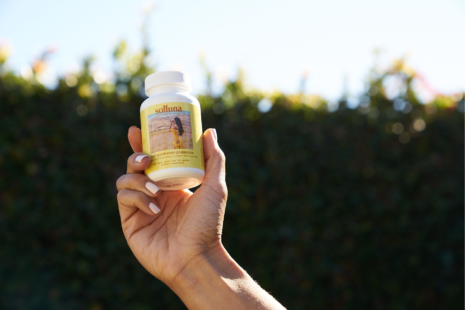 A bottle of Feel Good SBO Probiotics+ in Kimberly Snyder's hand