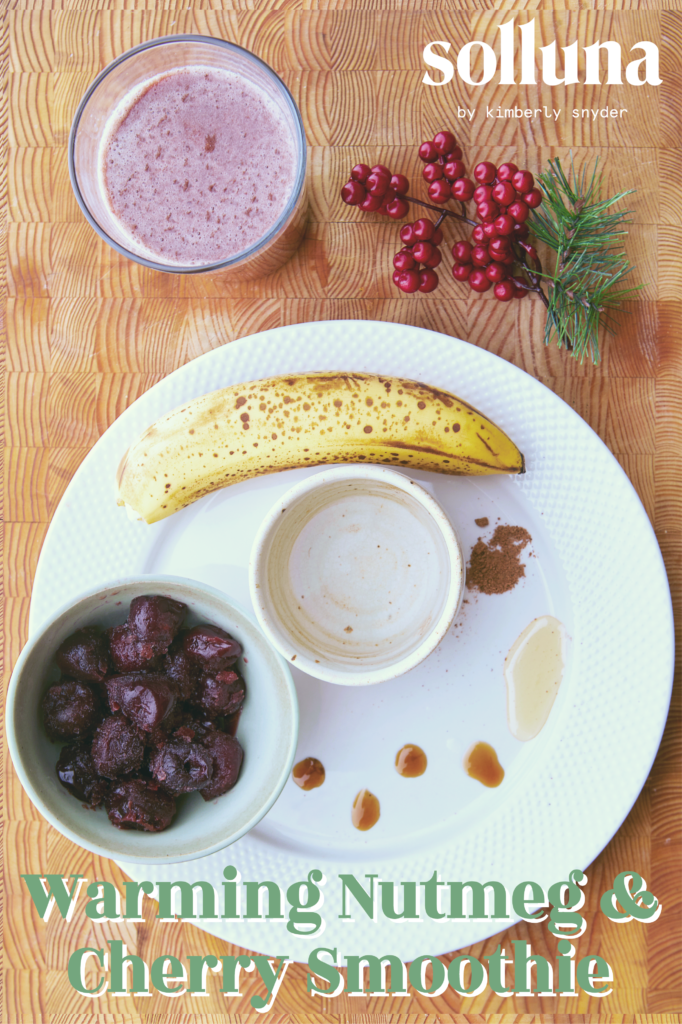 A warming nutmeg and cherry smoothie next to its ingredients.
