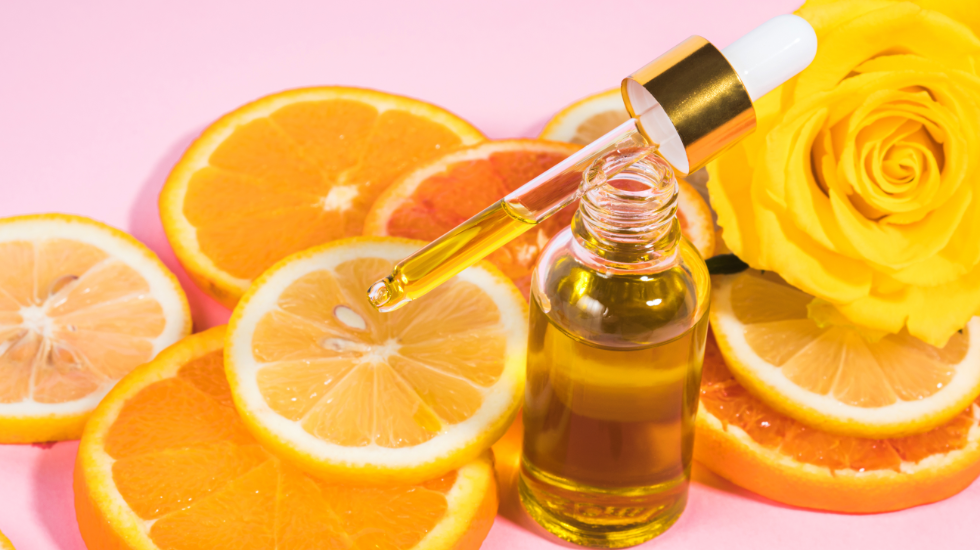 A dropper of Vitamin C serum on slices of oranges.